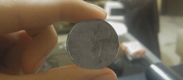 A video has emerged on YouTube to show what looked like a coin with the Reichsadler Nazi Party symbol and the words Nueva Alemania or New Germany - Sputnik International