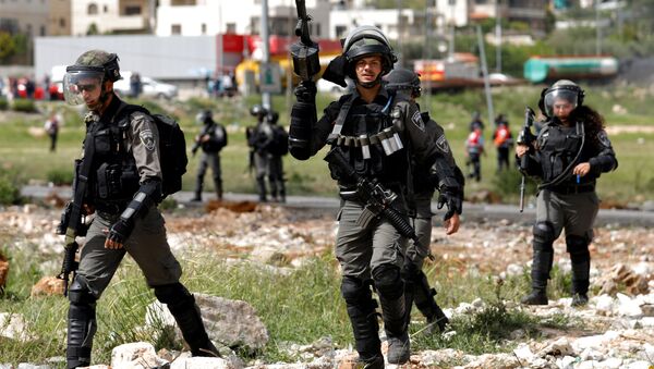 Israeli border police officers walk during clashes with Palestinians near the Jewish settlement of Beit El, near Ramallah, in the occupied West Bank April 13, 2018 - Sputnik International