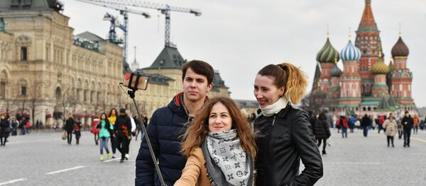 Tourists taking selfie on Red Square, Moscow. In the background St. Basil's Cathedral Tourists taking selfie on Red Square, Moscow. In the background St. Basil's Cathedral - Sputnik International