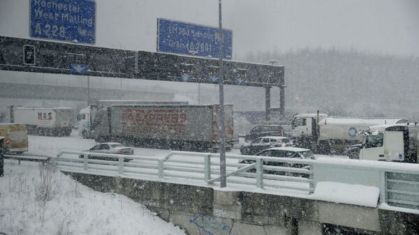 Vehicles crawl along a road as heavy snow falls in south east England - Sputnik International