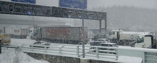 Vehicles crawl along a road as heavy snow falls in south east England - Sputnik International