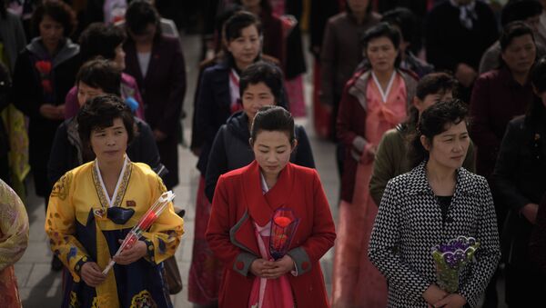 Women holding flowers arrive to pay their respects before the statues of late North Korean leaders Kim Il Sung and Kim Jong Il, at Mansu Hill in Pyongyang April 15, 2018. - Sputnik International