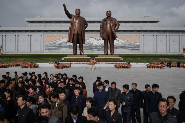 People walk away after paying their respects before the statues of late North Korean leaders Kim Il Sung and Kim Jong Il, at Mansu hill in Pyongyang April 15, 2018. - Sputnik International