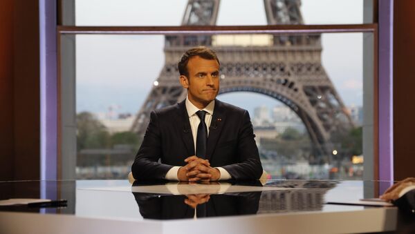 French President Emmanuel Macron poses on the TV set before an interview with RMC-BFM journalist Jean-Jacques Bourdin (R) and Mediapart investigative website journalist Edwy Plenel (L), at the Theatre National de Chaillot across from the Eiffel Tower in Paris, France, April 15, 2018 - Sputnik International
