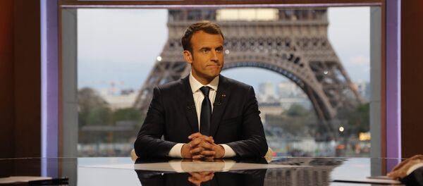 French President Emmanuel Macron poses on the TV set before an interview with RMC-BFM journalist Jean-Jacques Bourdin (R) and Mediapart investigative website journalist Edwy Plenel (L), at the Theatre National de Chaillot across from the Eiffel Tower in Paris, France, April 15, 2018 - Sputnik International