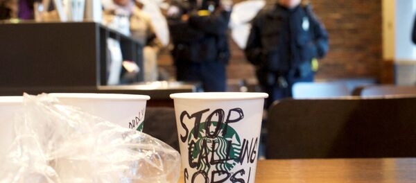 A Starbucks coffee cup with Stop Calling Cops! written on the side sits on a table as police monitor protestors demonstrating inside a Center City Starbucks, where two black men were arrested, in Philadelphia, Pennsylvania U.S., April 16, 2018. A Starbucks coffee cup with Stop Calling Cops! written on the side sits on a table as police monitor protestors demonstrating inside a Center City Starbucks, where two black men were arrested, in Philadelphia, Pennsylvania U.S., April 16, 2018. - Sputnik International