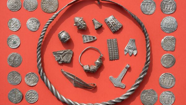 Parts of the silver treasure are pictured on a table in Schaprode, northern Germany on April 13, 2018. A 13-year-old boy and a hobby archaeologist have unearthed a significant trove in Germany which may have belonged to the legendary Danish king Harald Bluetooth who brought Christianity to Denmark - Sputnik International