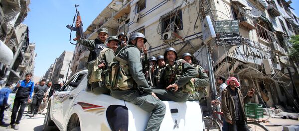Members of the Syrian police hold their weapons as they sit on a back of a truck at the city of Douma, Damascus, Syria April 16, 2018 Members of the Syrian police hold their weapons as they sit on a back of a truck at the city of Douma, Damascus, Syria April 16, 2018 - Sputnik International