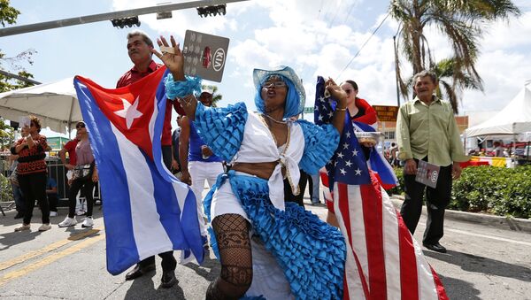 Lucina Michel, right, and her husband Caridad Osorio wave American and Cuban flags as they dance to music at the Calle Ocho Festival, Sunday, March 11, 2018, in Miami - Sputnik International