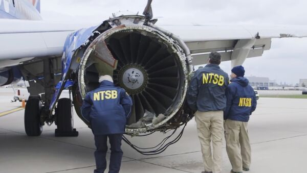 In this Tuesday, April 17, 2018 frame from video, a National Transportation Safety Board investigator examines damage to the engine of the Southwest Airlines plane that made an emergency landing at Philadelphia International Airport in Philadelphia - Sputnik International