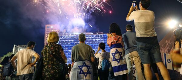 Israelis look at a fireworks set to begin the celebrations for Israel's 70th Independence Day, at Rabin square in Tel Aviv, Israel, Wednesday, April 18, 2018 - Sputnik International