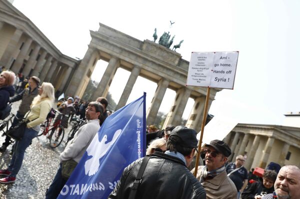 A protester holds a poster during the demonstration against airstrikes on Syria in Berlin, Germany A protester holds a poster during the demonstration against airstrikes on Syria in Berlin, Germany - Sputnik International