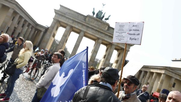 A protester holds a poster during the demonstration against airstrikes on Syria in Berlin, Germany - Sputnik International