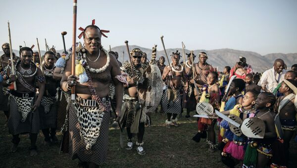 King Mswati III of Swaziland (L) walks in a traditional show of appreciation for maidens as they sing and dance on the last day of the annual royal Reed Dance at the Ludzidzini Royal palace on August 31, 2015 in Lobamba, Swaziland - Sputnik International