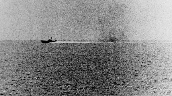 Photograph taken from the U.S. Navy destroyer USS Maddox (DD-731) during her engagement with three North Vietnamese motor torpedo boats in the Gulf of Tonkin, 2 August 1964. The view shows one of the boats racing by, with what appears to be smoke from Maddox' shells in its wake. - Sputnik International