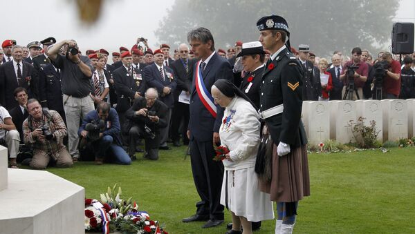 In this file photograph taken on August 19, 2012, Sister and former nurse Marie-Agnes Valois (C) lays down flowers in front of a memorial near Dieppe northwestern France, during the 70th anniversary ceremony of the Dieppe Raid, held in memory of the Second World War Allied attack on the German-occupied port of Dieppe on August 19, 1942 - Sputnik International