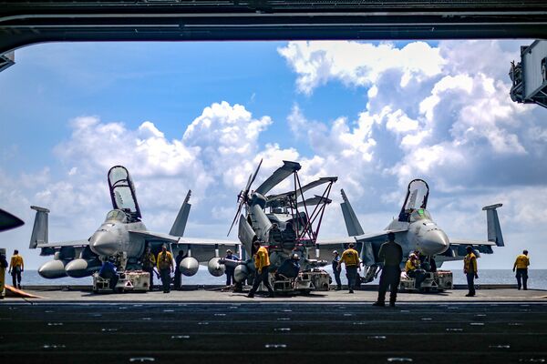 U.S. Navy sailors move aircraft from an elevator into the hangar bay of the aircraft carrier USS Theodore Roosevelt in the South China Sea April 8, 2018. Picture taken April 8, 2018 U.S. Navy sailors move aircraft from an elevator into the hangar bay of the aircraft carrier USS Theodore Roosevelt in the South China Sea April 8, 2018. Picture taken April 8, 2018 - Sputnik International