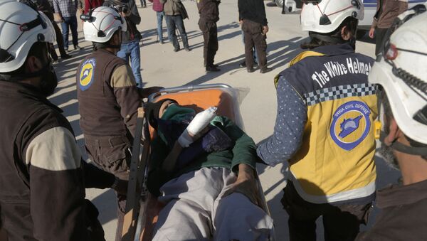 Syrian Civil Defence (known as the White Helmets) carry an injured man as Jaish al-Islam fighters and their families arrive from the former rebel bastion's main town of Douma at the Abu al-Zindeen checkpoint controlled by Turkish-backed rebel fighters near the northern Syrian town of al-Bab, on April 4, 2018 - Sputnik International