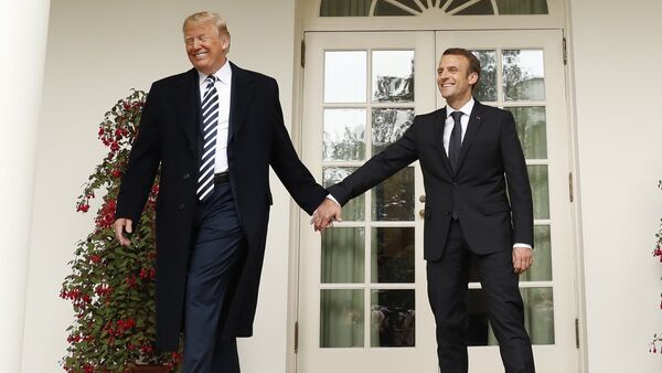 U.S. President Donald Trump and French President Emmanuel Macron hold hands as they walk down the West Wing colonnade past the Rose Garden at the White House in Washington, U.S., April 24, 2018 - Sputnik International