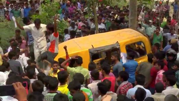 People gather around a school bus after it collided with a train in Uttar Pradesh, India April 26, 2018, in this screen grab taken from video - Sputnik International