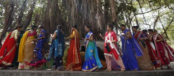 (File) Indian Hindu married women tie cotton threads around a Banyan tree as they perform rituals on the first day of Vat Savitri festival in Ahmadabad, India, Tuesday, June 6, 2017 - Sputnik International