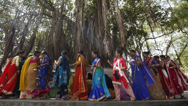 (File) Indian Hindu married women tie cotton threads around a Banyan tree as they perform rituals on the first day of Vat Savitri festival in Ahmadabad, India, Tuesday, June 6, 2017 - Sputnik International