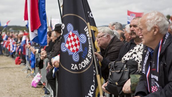 Visitors hold flags including a black one reading Za Dom Spremni or For Homeland Ready, a chant used by pro-nazis during WWII, attend a rally in Bleiburg, Austria, Saturday, May 14, 2016 - Sputnik International