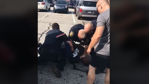 Former NFL player Desmond Marrow is pinned to the ground by three officers of the Henry County Police Department in Georgia as they arrest him. - Sputnik International