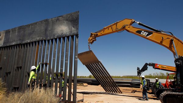 Construction workers are seen next to heavy machinery while working on new bollard wall in Santa Teresa, New Mexico, as seen from the Mexican side of the border in San Jeronimo, on the outskirts of Ciudad Juarez, Mexico April 23, 2018 - Sputnik International