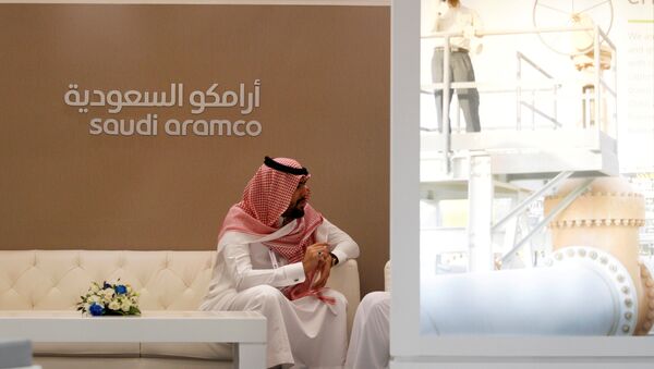 A Saudi Aramco employee sits in the area of its stand at the Middle East Petrotech 2016, an exhibition and conference for the refining and petrochemical industries, in Manama, Bahrain, September 27, 2016 - Sputnik International