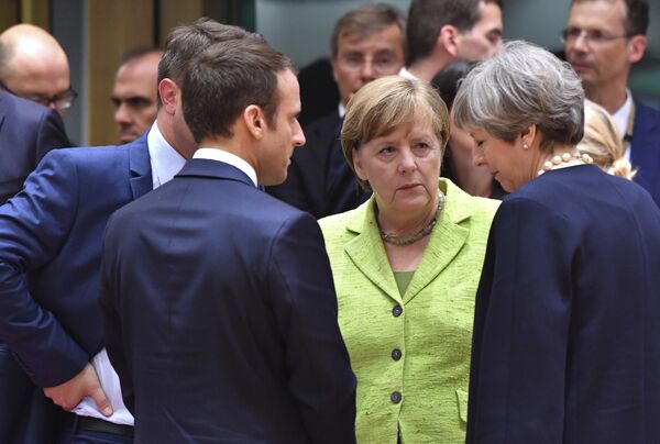 French President Emmanuel Macron, second left, speaks with German Chancellor Angela Merkel, center, and British Prime Minister Theresa May, right, during a round table meeting at an EU summit in Brussels on Thursday, June 22, 2017 French President Emmanuel Macron, second left, speaks with German Chancellor Angela Merkel, center, and British Prime Minister Theresa May, right, during a round table meeting at an EU summit in Brussels on Thursday, June 22, 2017 - Sputnik International