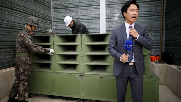 A reporter prepares a news report as South Korean soldiers dismantle loudspeakers that were set up for propaganda broadcasts near the demilitarized zone separating the two Koreas in Paju, South Korea, May 1, 2018. - Sputnik International