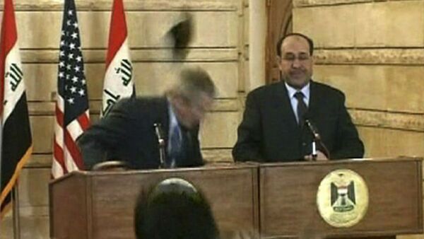 In this image from APTN video, a man throws a shoe at President George W. Bush during a news conference with Iraq Prime Minister Nouri al-Maliki on Sunday, Dec. 14, 2008, in Baghdad. The man threw two shoes at Bush, one after another. Bush ducked both throws, and neither man was hit. - Sputnik International