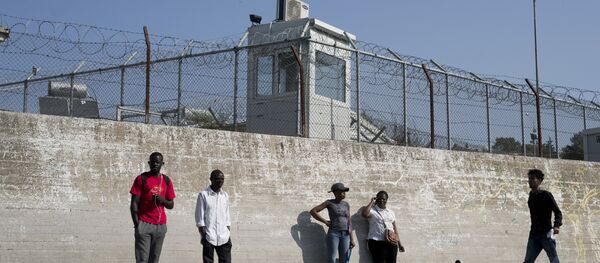 Migrants stand outside the walls of the Moria refugee camp on the northeastern Aegean island of Lesbos, Greece, Wednesday, May 2, 2018 Migrants stand outside the walls of the Moria refugee camp on the northeastern Aegean island of Lesbos, Greece, Wednesday, May 2, 2018 - Sputnik International