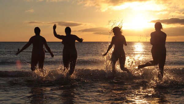 Nudists take part in the annual North East Skinny Dip as the sun rises at Druridge Bay in Northumberland, northeast England on September 22, 2013 - Sputnik International