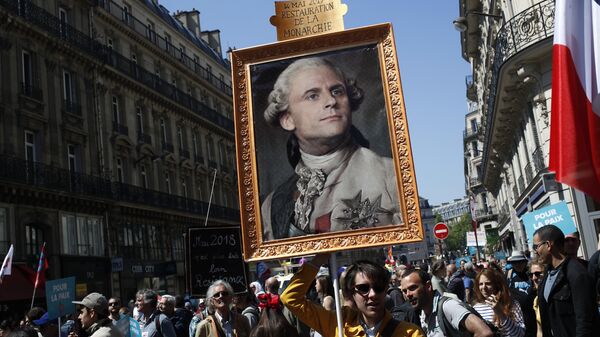 A protester carries a picture of French president Macron depicted as king Louis XIV during a protest in Paris, France, Saturday, May 5, 2018 - Sputnik International