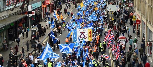 Anti-independence supporters wave Union Jack flags (R) as thousands of demonstrators carry Saltire flags, the national flag of Scotland, as they march in support of Scottish independence through the streets of Glasgow, on May 5, 2018 - Sputnik International