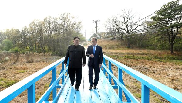 South Korean President Moon Jae-in and North Korean leader Kim Jong Un walk together at the truce village of Panmunjom inside the demilitarized zone separating the two Koreas, South Korea, April 27, 2018 - Sputnik International