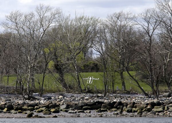 In this April 29, 2018 photo, a cross of wood and stones is seen on Hart Island in New York The island, which has served for 150 years as New York’s burial ground for the poor and nameless, like a traditional cemetery with manicured lawns or even headstones - Sputnik International