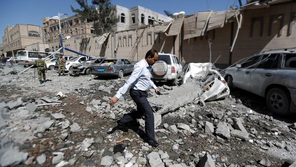 A man walks past damaged cars outside the Presidential Compound after it was hit by air strikes in Sanaa, Yemen May 7, 2018 - Sputnik International