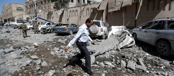 A man walks past damaged cars outside the Presidential Compound after it was hit by air strikes in Sanaa, Yemen May 7, 2018 - Sputnik International