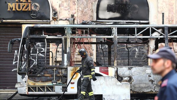 A firefighter walks next to a burned bus in downtown Rome, Italy May 8, 2018 - Sputnik International