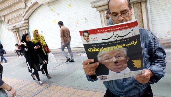 An Iranian man reads a copy of the daily newspaper 'Omid Javan' bearing a picture of US President Donald Trump with a headline that reads in Persian Crazy Trump and logical JCPOA (Joint Comprehensive Plan of Action), on October 14, 2017, in front of a kiosk in the capital Tehran - Sputnik International