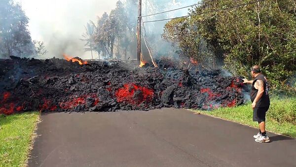 In this photo taken from video an unidentified man gets close to a lava flow advancing down a road in the Leilani Estates subdivision near Pahoa on the island of Hawaii Monday, May 7, 2018 - Sputnik International