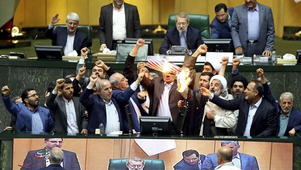 Iranian lawmakers burn two pieces of papers representing the U.S. flag and the nuclear deal as they chant slogans against the U.S. at the parliament in Tehran, Iran, Wednesday, May 9, 2018 - Sputnik International