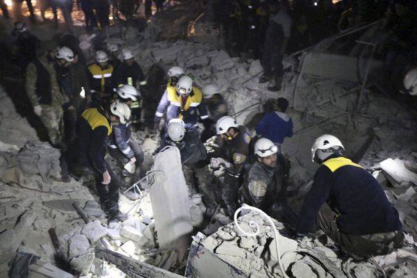 This photo provided on Sunday, Jan. 7, 2018 by the Syrian Civil Defense White Helmets, which has been authenticated based on its contents and other AP reporting, shows Civil Defense workers inspecting a damages building after a bombing that targeted the office of Ajnad al-Koukaz, a militant group consisting of foreign fighters mostly from the Caucuses and Russia, in Idlib, Syria This photo provided on Sunday, Jan. 7, 2018 by the Syrian Civil Defense White Helmets, which has been authenticated based on its contents and other AP reporting, shows Civil Defense workers inspecting a damages building after a bombing that targeted the office of Ajnad al-Koukaz, a militant group consisting of foreign fighters mostly from the Caucuses and Russia, in Idlib, Syria - Sputnik International