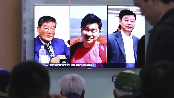People watch a TV news report on screen, showing portraits of three Americans, Kim Dong Chul, left, Tony Kim and Kim Hak Song, right, detained in the North Korea at the Seoul Railway Station in Seoul, South Korea, Thursday, May 3, 2018. - Sputnik International