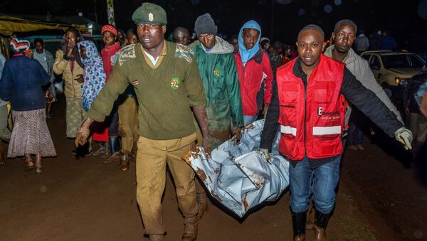 People carry a victim's body from a residential area after Patel dam burst its bank at Solai, about 40 kilometres north of Nakuru, Kenya, on May 10, 2018 - Sputnik International