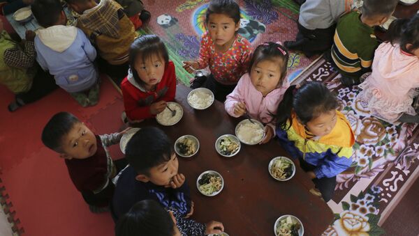In this May 9, 2018 photo provided by the World Food Program (WFP), children eat a meal at a nursery and kindergarten where WFP provides food assistance in Sinwon county in North Korea's South Hwanghae province - Sputnik International
