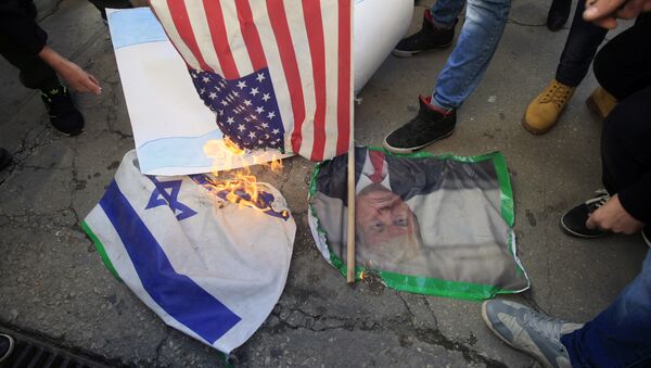 Lebanese and Palestinians students, burn a picture of U S. President Donald Trump, an American flag and an Israeli flag, as they take part in a protest at the Lebanese University, in the southern port city of Sidon, Lebanon, Thursday, Dec. 7, 2017, against U.S. President Donald Trump's decisions to recognize Jerusalem as the capital of Israel - Sputnik International